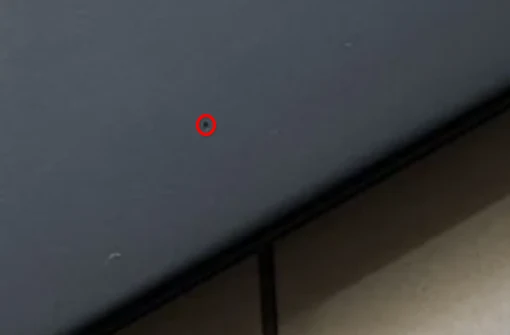 Close-up lid ThinkPad X1 Nano — satu titik kecil pada permukaan lid (dilingkari merah)