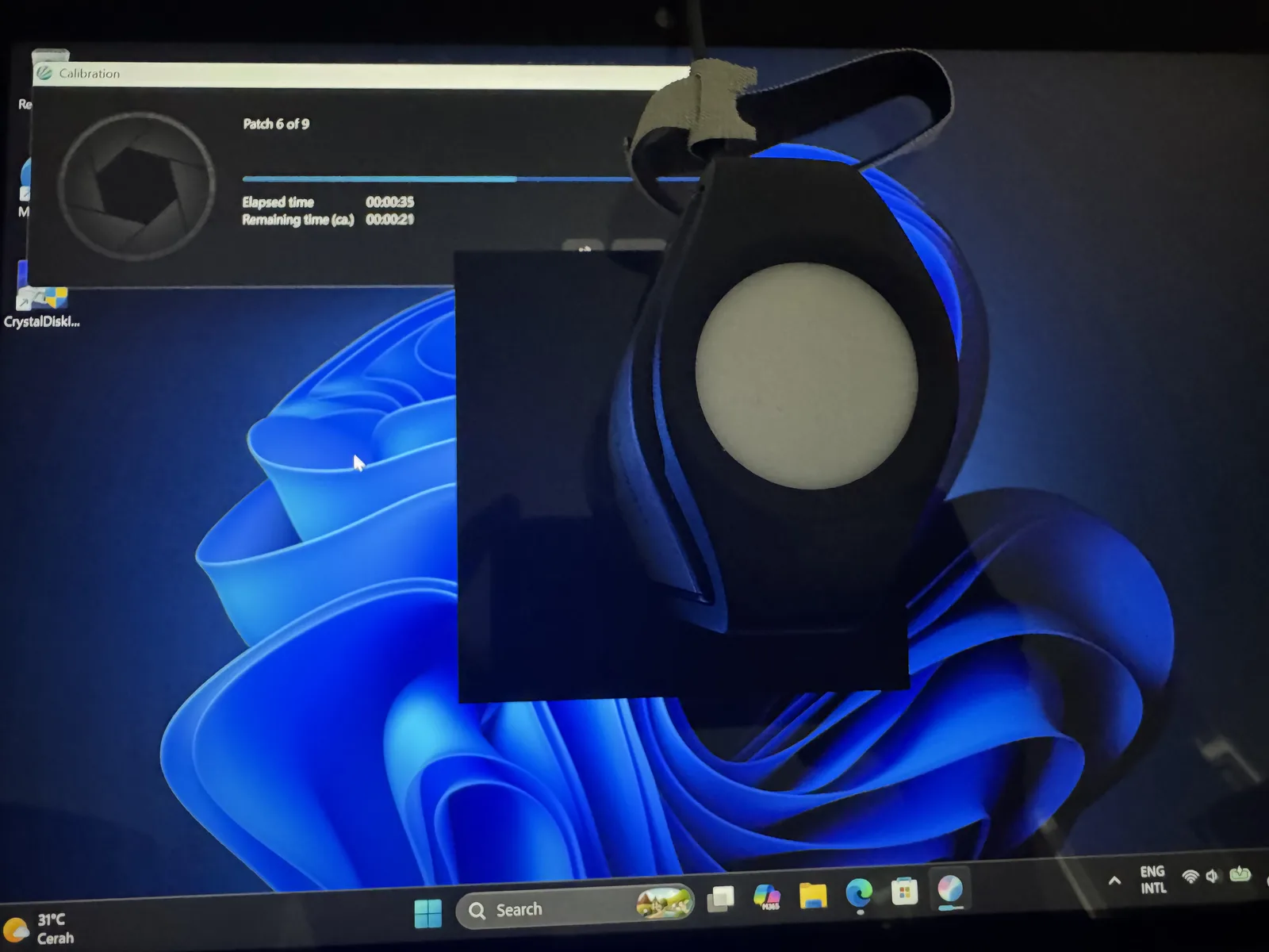 Kolorimeter i1 Display Studio menempel di layar saat kalibrasi